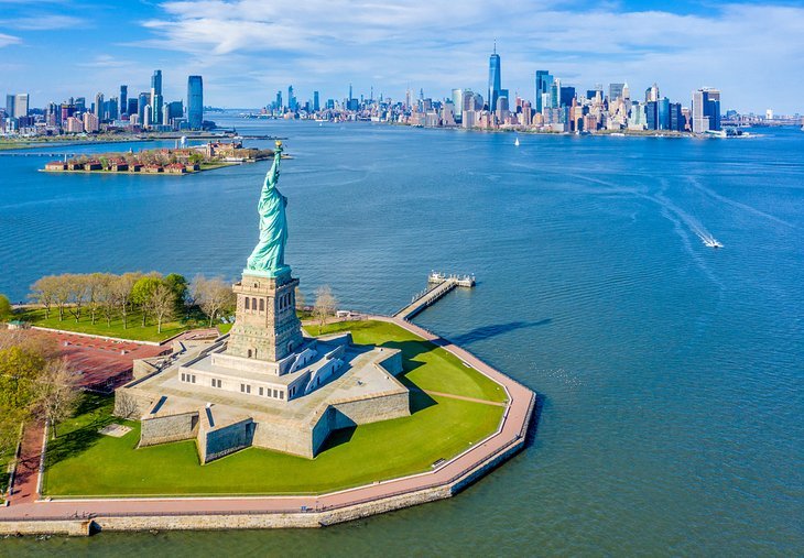 Staten Island Ferry passing by Statue of Liberty with Manhattan skyline in distance
